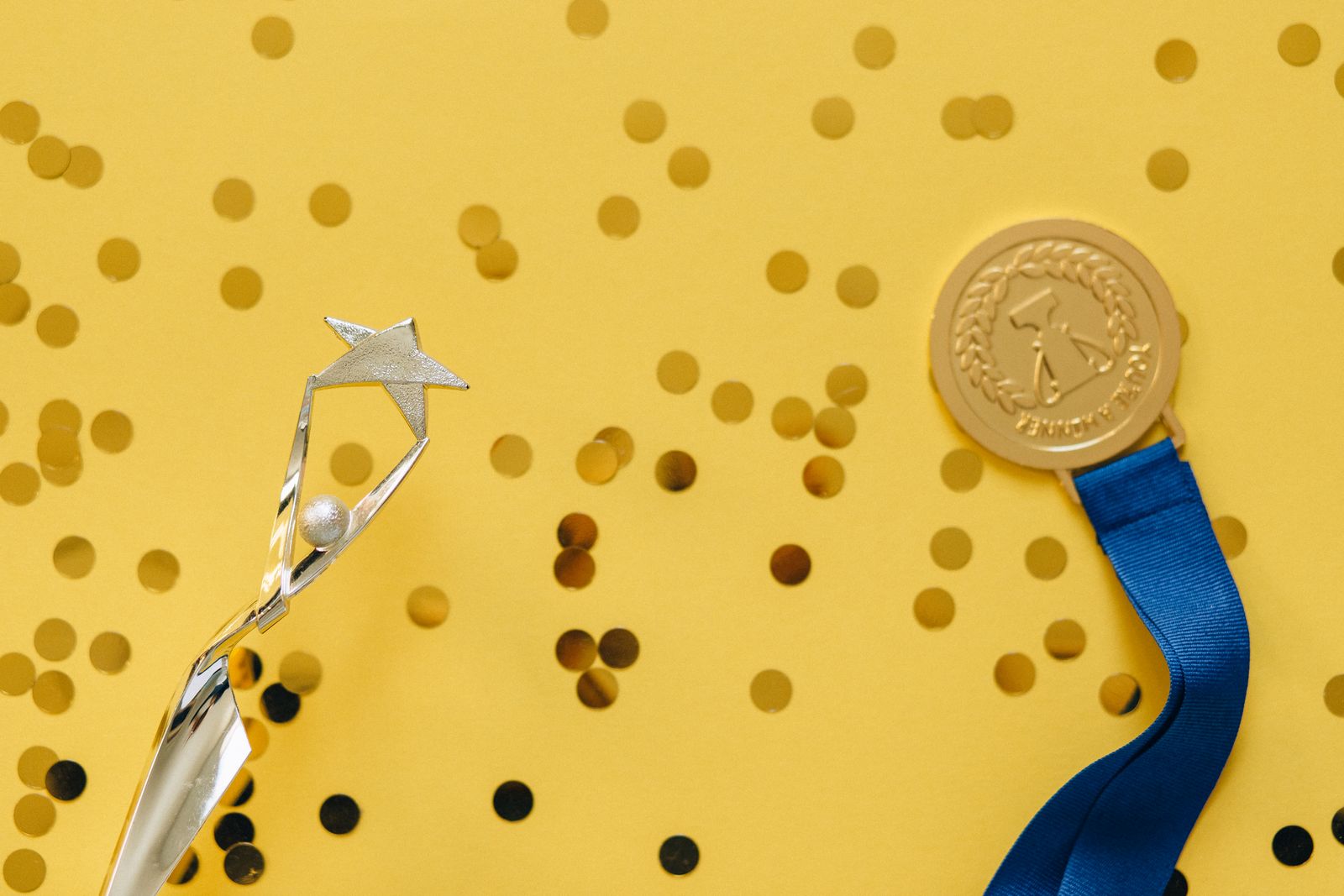 A trophy and medal surrounded by confetti