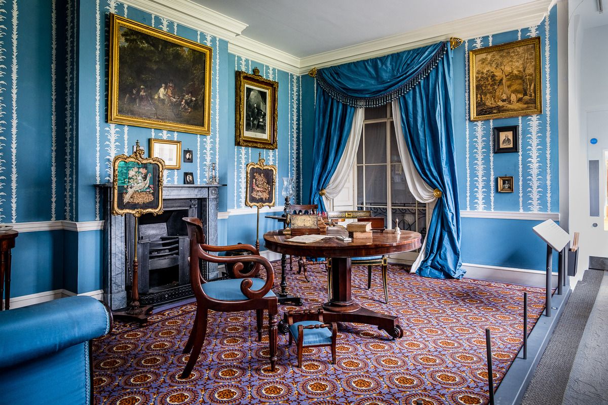 A furnished period room with blue walls at the Museum of the Home.