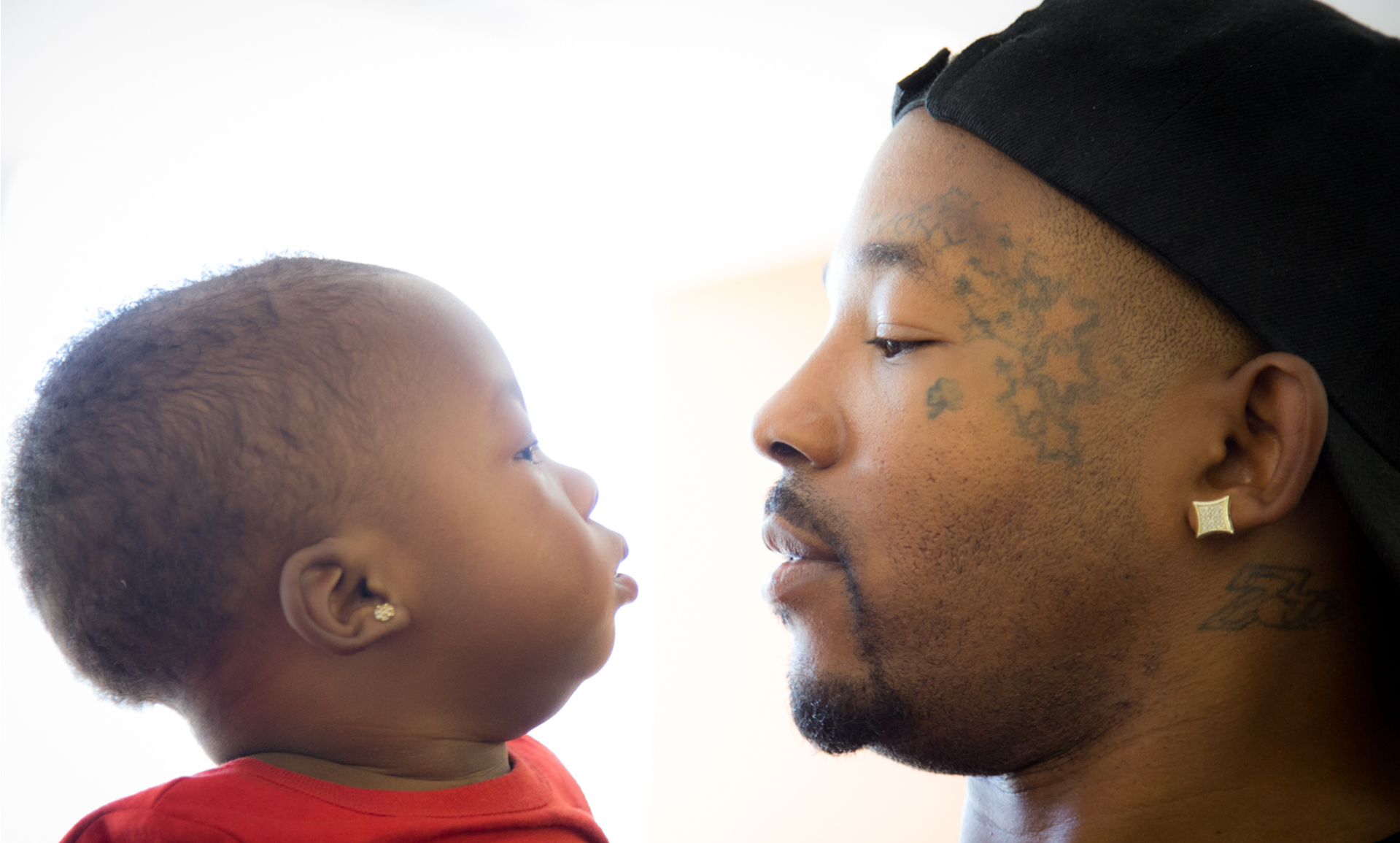 A father holding a young child in an image featured by Homeboy Industries.