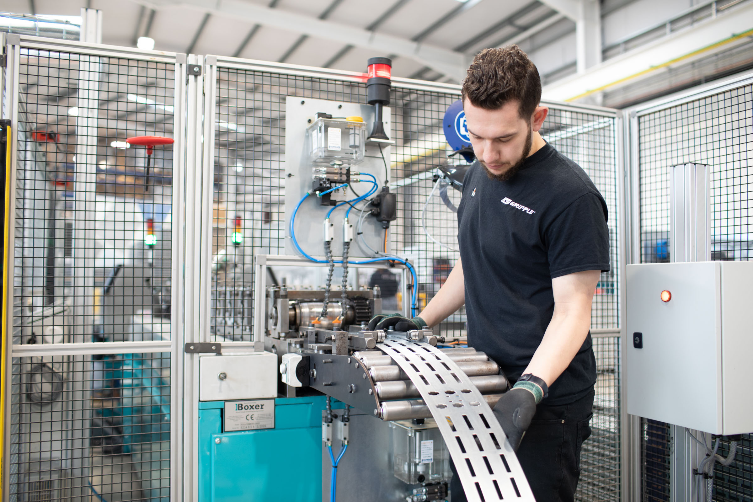 A Gripple employee working with manufacturing equipment.