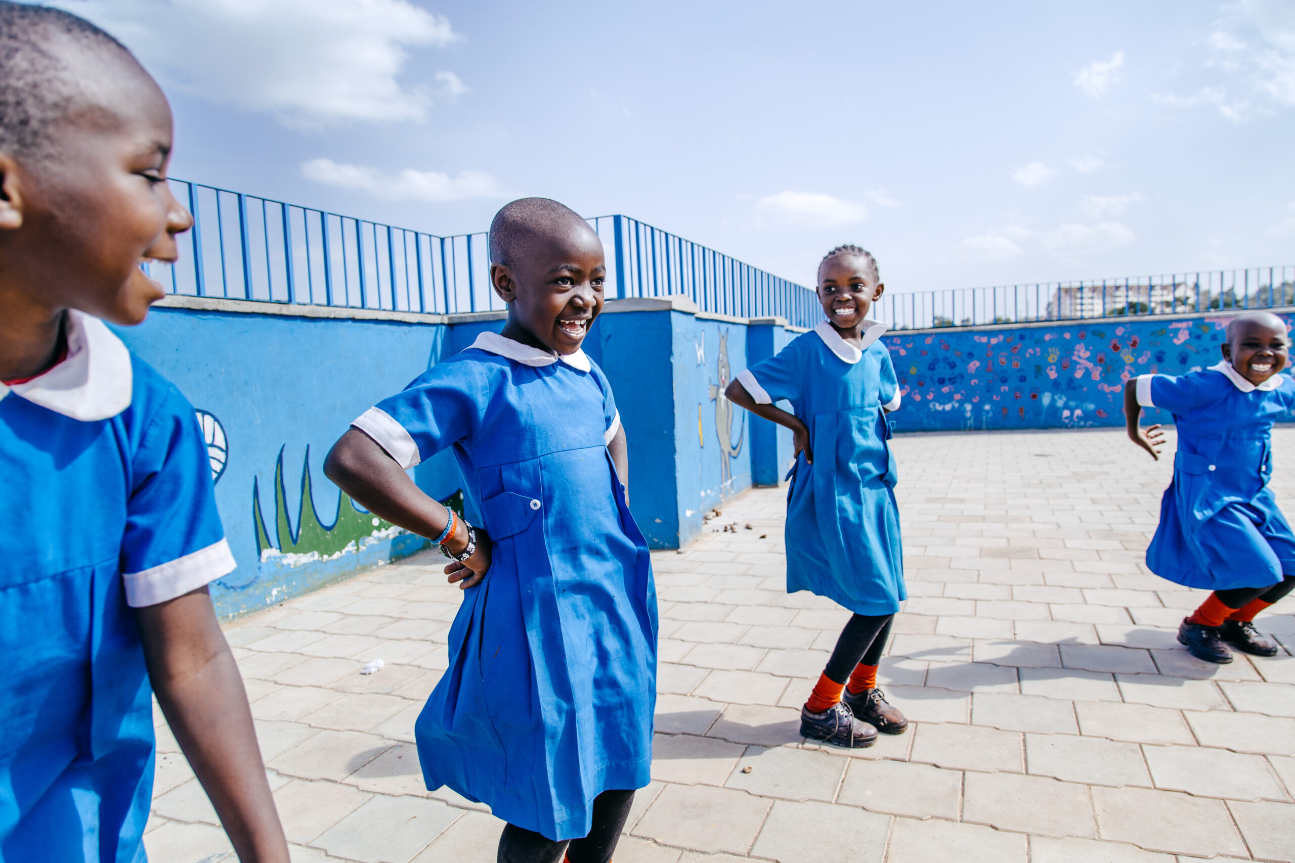 Children in blue school uniforms playing outdoors, featured in SHOFCO’s humanitarian prize announcement.
